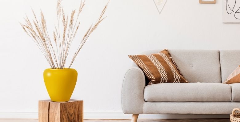 Yellow FRP Planter on a wooden box near sofa in a living room