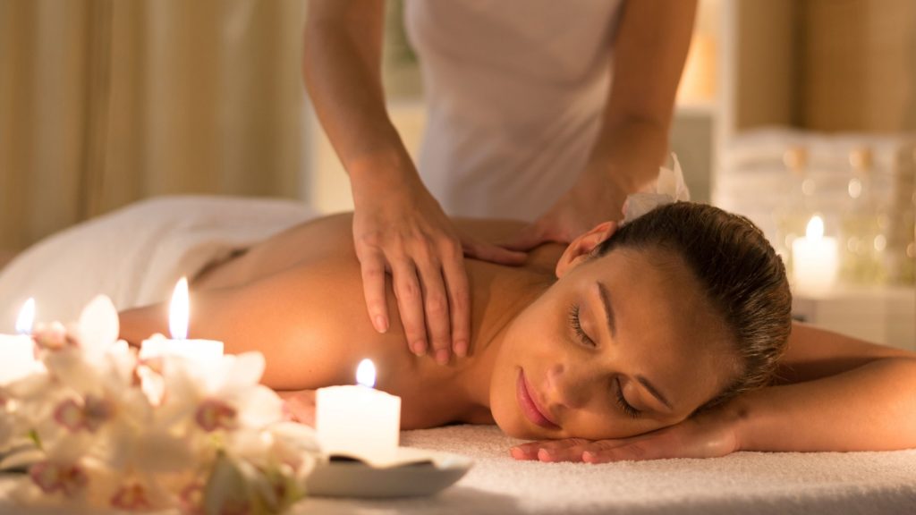 a woman taking her massage from therapists.