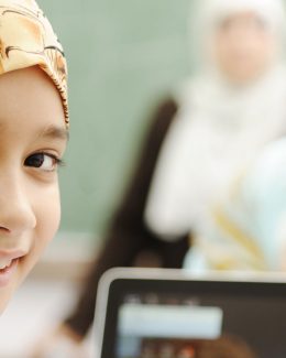 A kids with his laptop taking online Noorani Qaida class